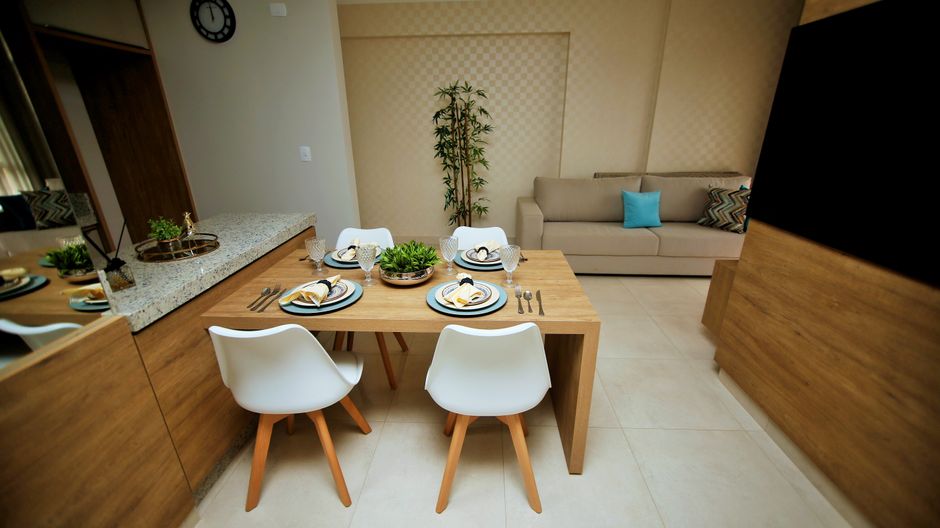 Stylish dining area with wooden table, white chairs, and lush plants.