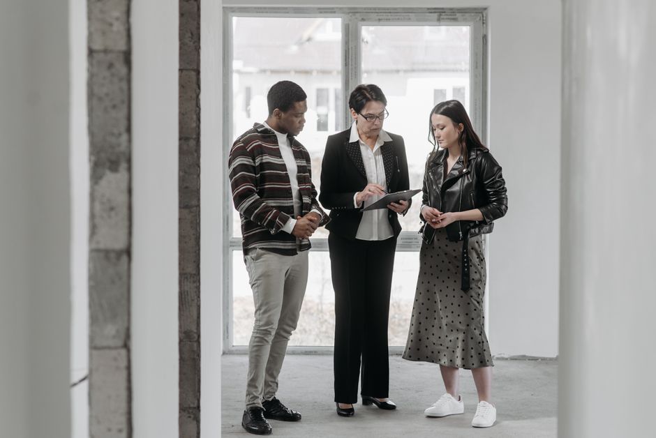 A real estate agent discusses property details with potential buyers during a house viewing.