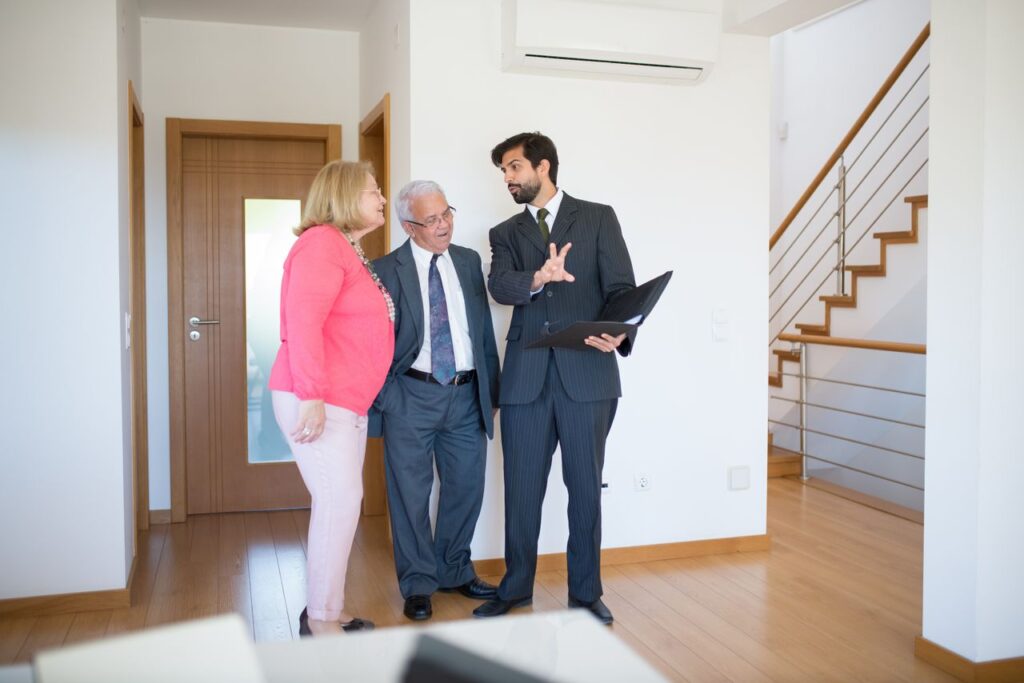 Realtor showing property to senior couple inside a modern home in Portugal.